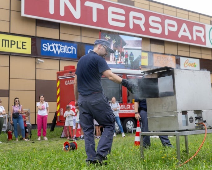 Vaja z gasilcem pred trgovino INTERSPAR