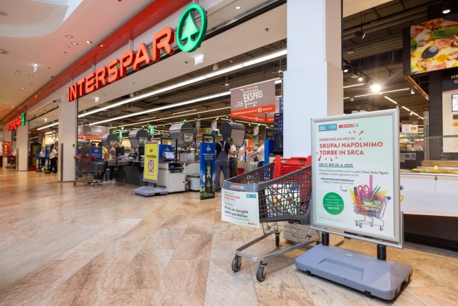 Vhod v trgovino Interspar, voziček za zbiranje šolskih potrebščin v Sparovi dobrodelni akciji