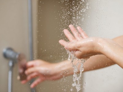 Roka preverja temparaturo vode pod tušem