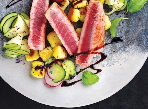 Tunin steak z njoki in zelenjavo na sivem krožniku