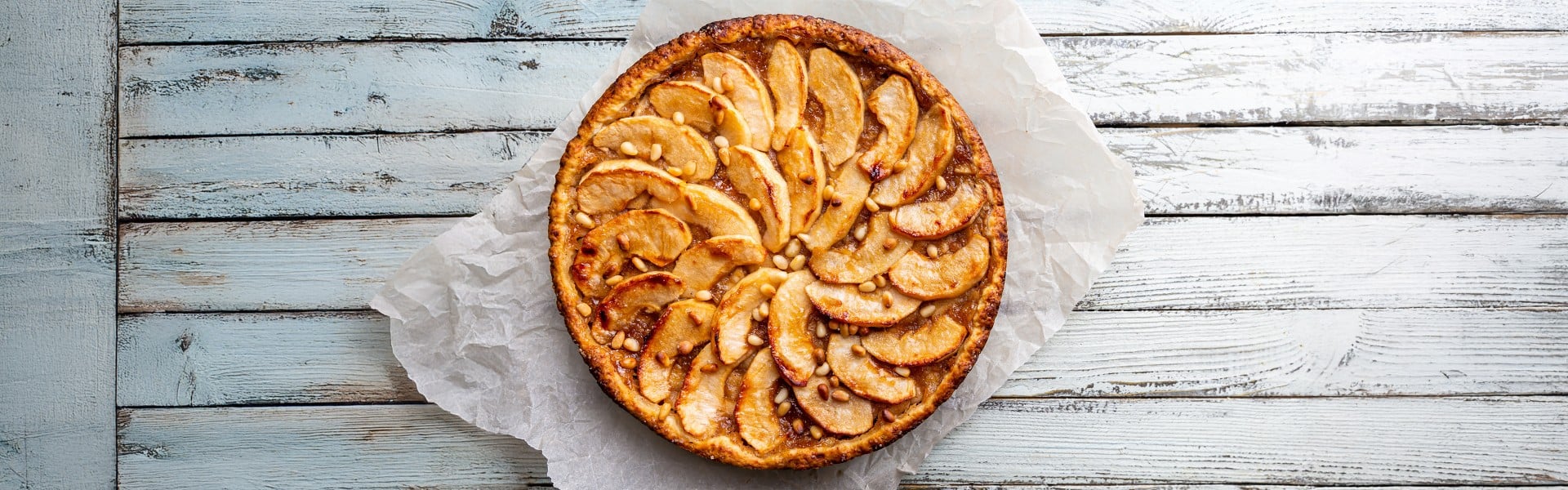 Sveže pečen jabolčni tart na leseni podlagi