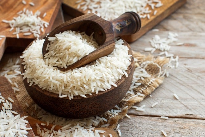 Basmati riž v posodici z leseno merico.
