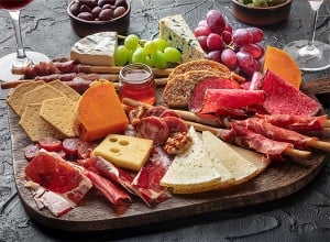 Narezek s salamo in sirom na leseni deski