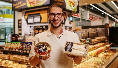 Luka Pangos s svojimi izdelki SPAR To Go v rokah, pred oddelkom SPAR To Go