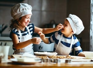 Otroka se zabavata med peko piškotov