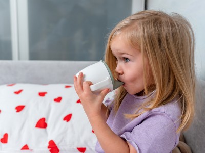 Majhna punčka pred spanjem pije iz stekleničke