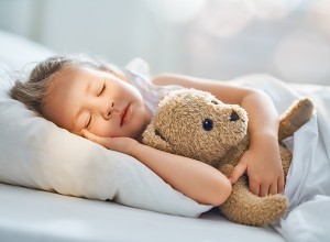 Majhna punčka mirno spi v postelje