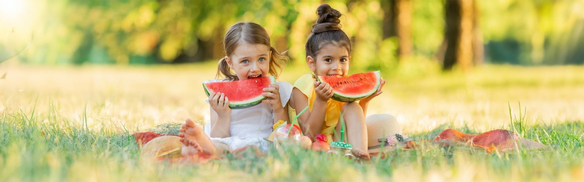 Dve punčki jesta lubenico na pikniku