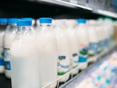 Mleko v plastičnih steklenicah na policah v trgovini