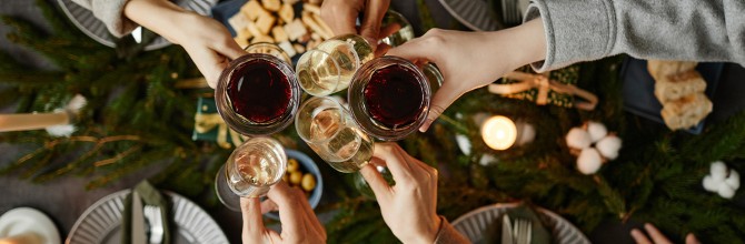 Prijatelji nazdavljajo s kozarci vina, praznično vzdušje