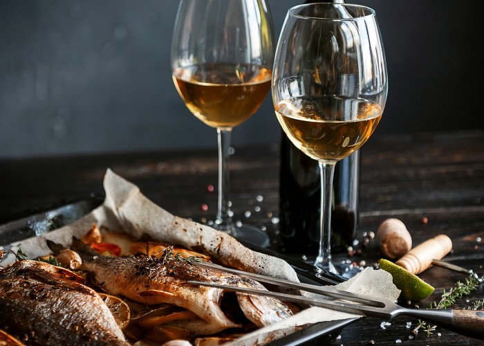 Pečena orada in kozarca belega vina