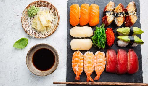 Set of sushi and maki with soy sauce over white background. Top view with copy space