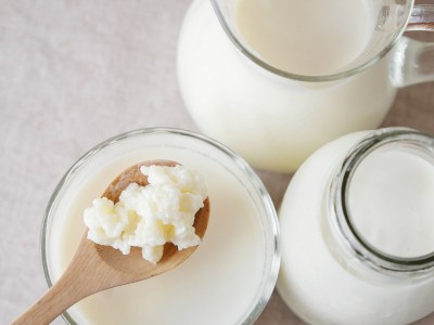 Žlica zajema kefir iz steklene posode