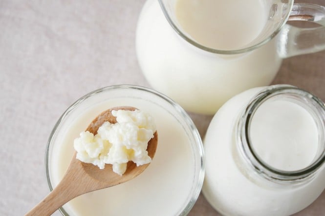 Žlica zajema kefir iz steklene posode