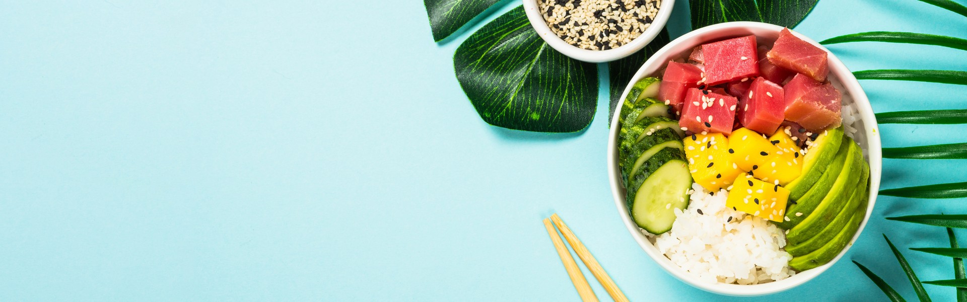 Poke bowl na modrem ozadju s palminimi listi