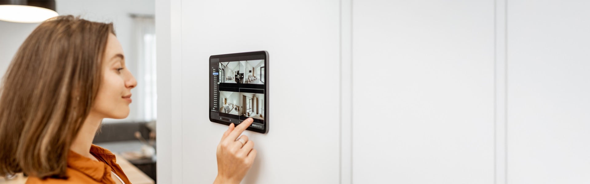 Mlada ženska doma gleda videoposnetke z varnostnih kamer na pametnem nadzornem sistemu