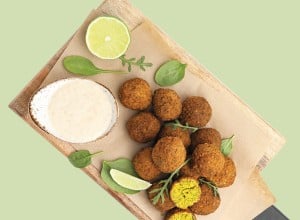 Veganski medaljoni z omako in limonami na leseni dilci