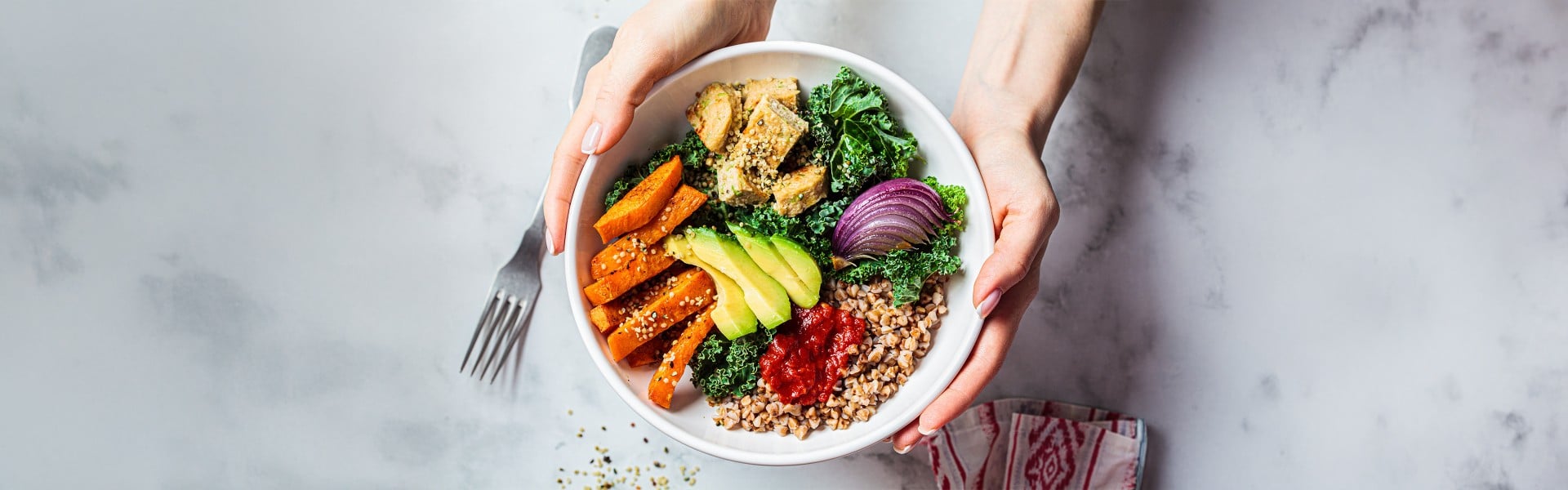 Veganska zelenjavna bovla v ženskih rokah