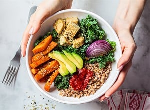 Veganska zelenjavna bovla v ženskih rokah