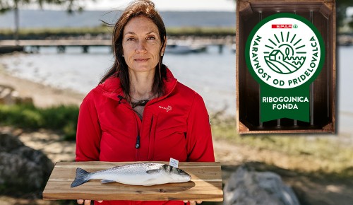 Ribogojnica Fonda Ribogojnica Fonda, ženska v rokah drži surovega brancina na deski