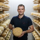 Predstavnik kmetije Kukenberger ki drži kolut sira 