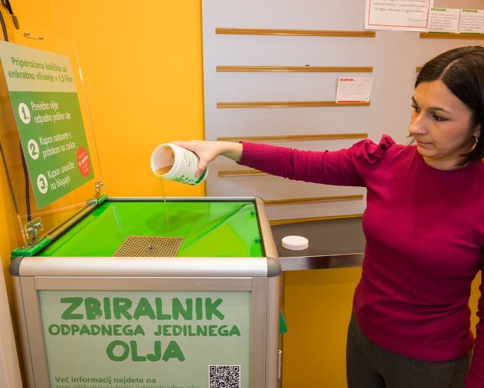 Gospa zliva olje v zbiralnik odpadnega jedilnega olja